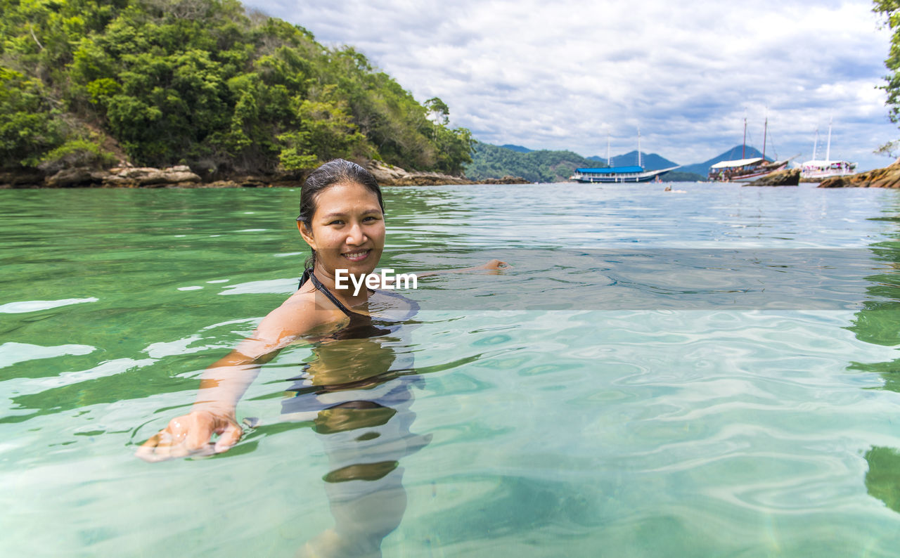 Woman swimming at the green lagoon on the tropical island ilha grande