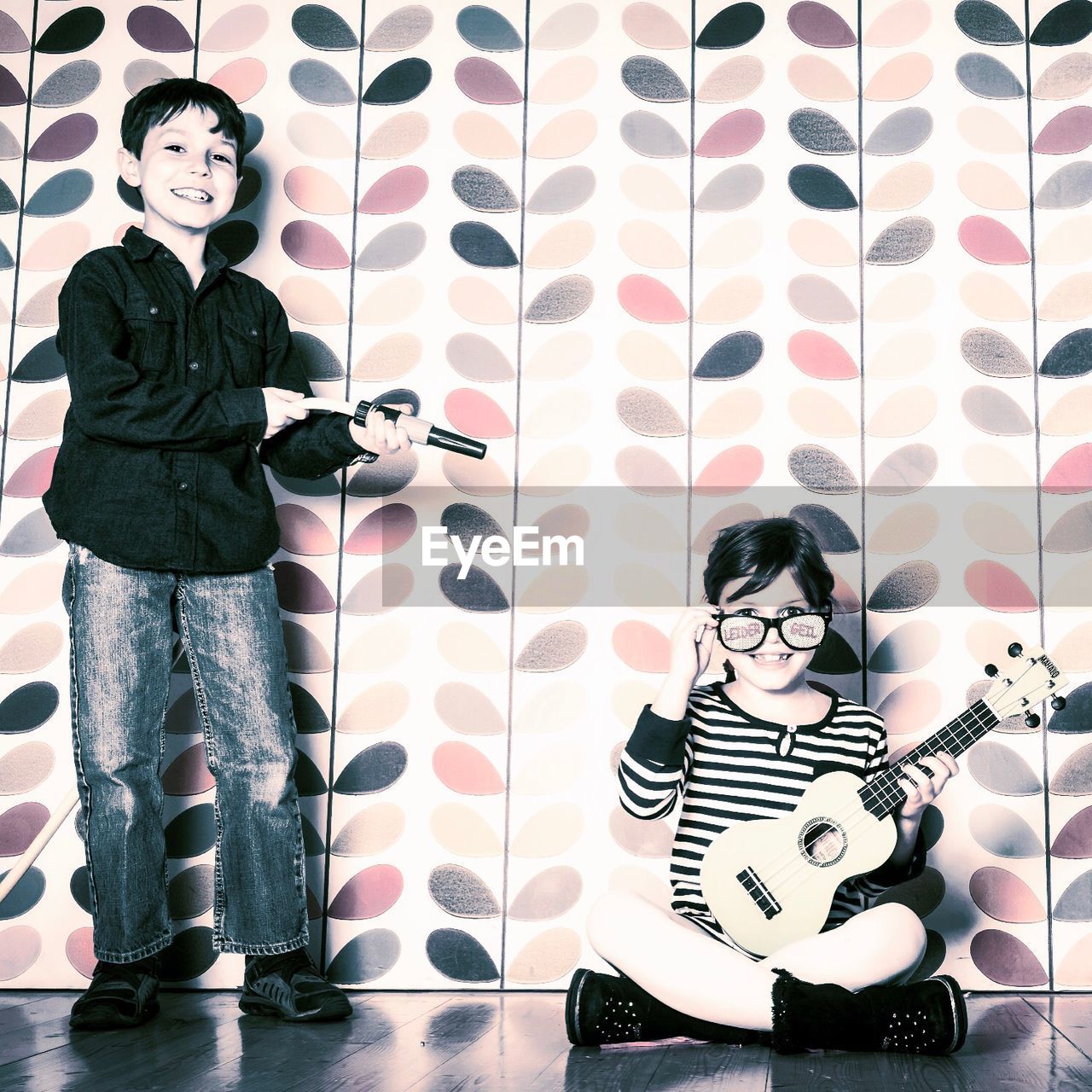 PORTRAIT OF BOYS STANDING AGAINST WALL