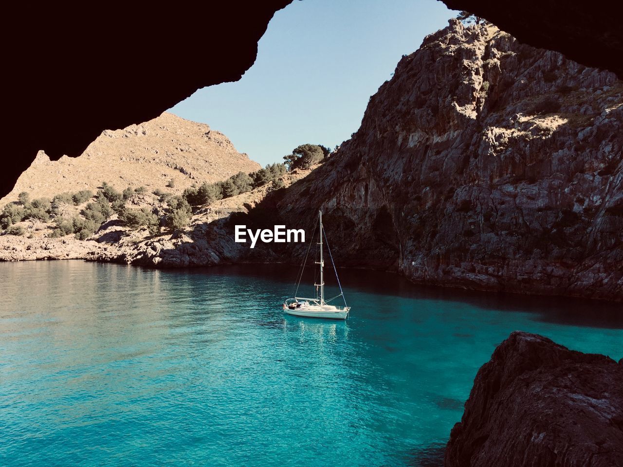 High angle view of sailboat sailing on sea against mountain