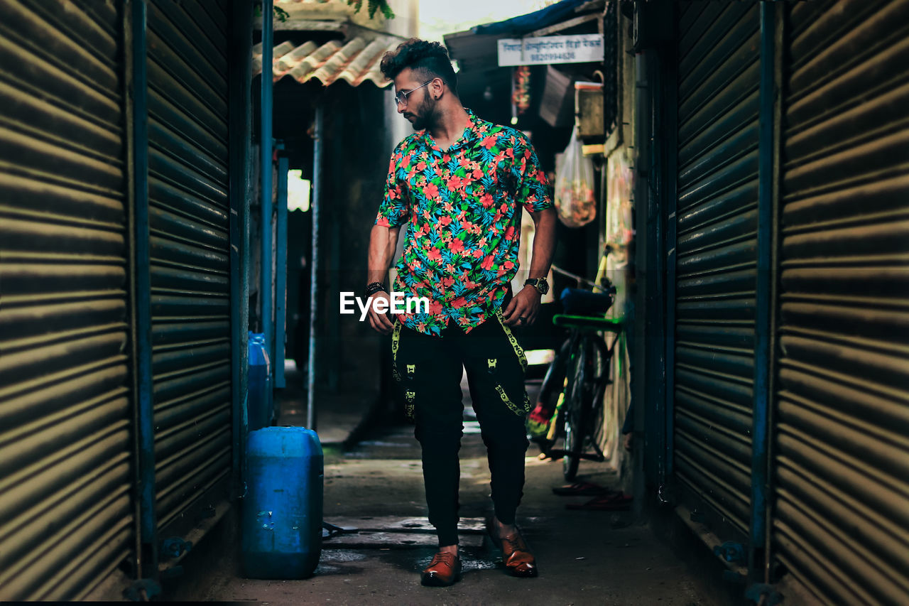Young man standing in narrow alley