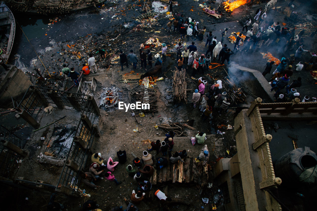 Varanasi, india - february, 2018: aerial view of place of cremation ceremony with various funeral piles and people looking at fire