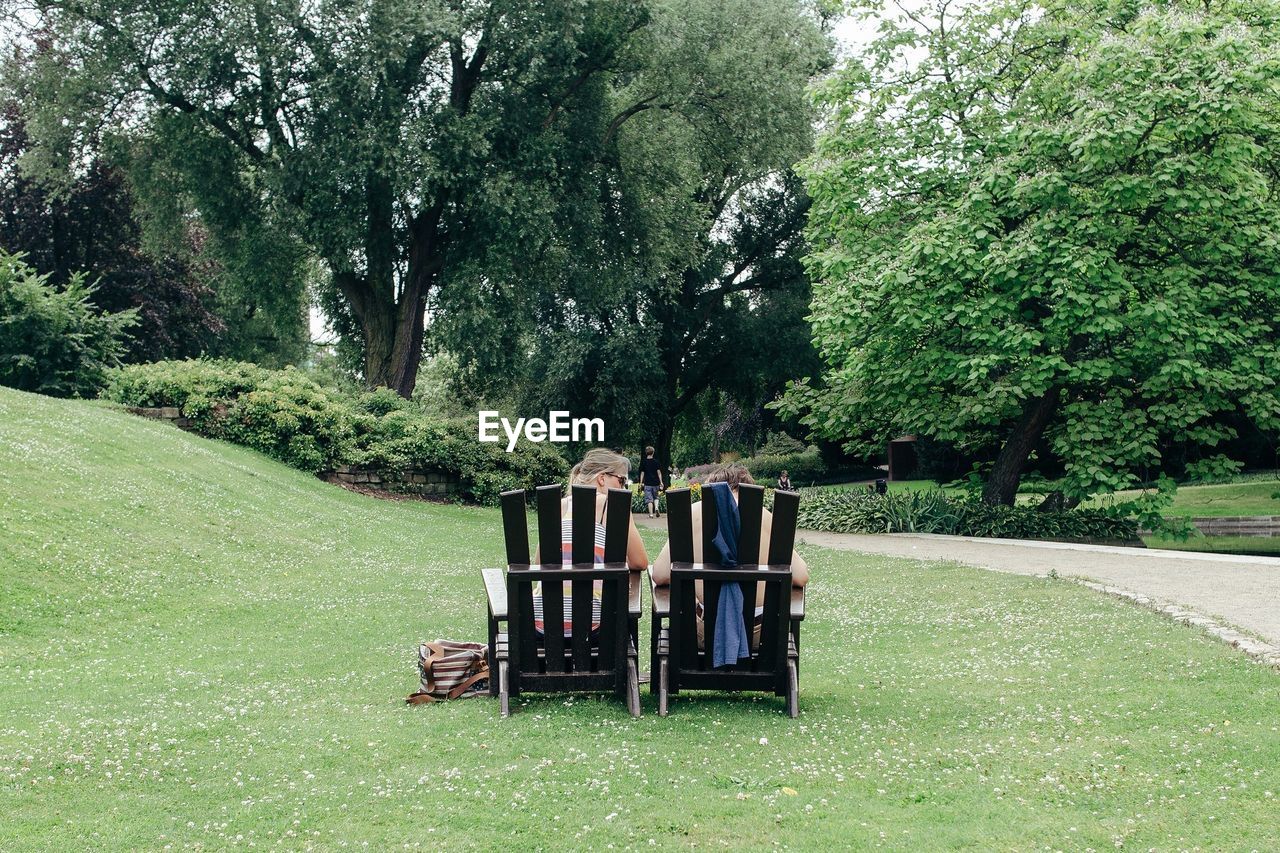 Rear view of a couple sitting on chairs at park