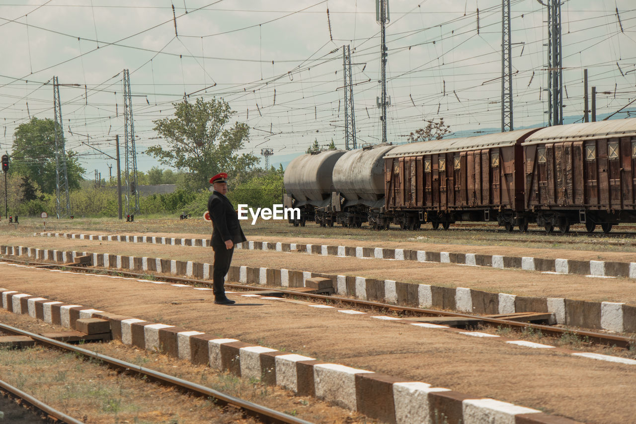 MAN STANDING ON RAILROAD TRACK AGAINST TRAIN