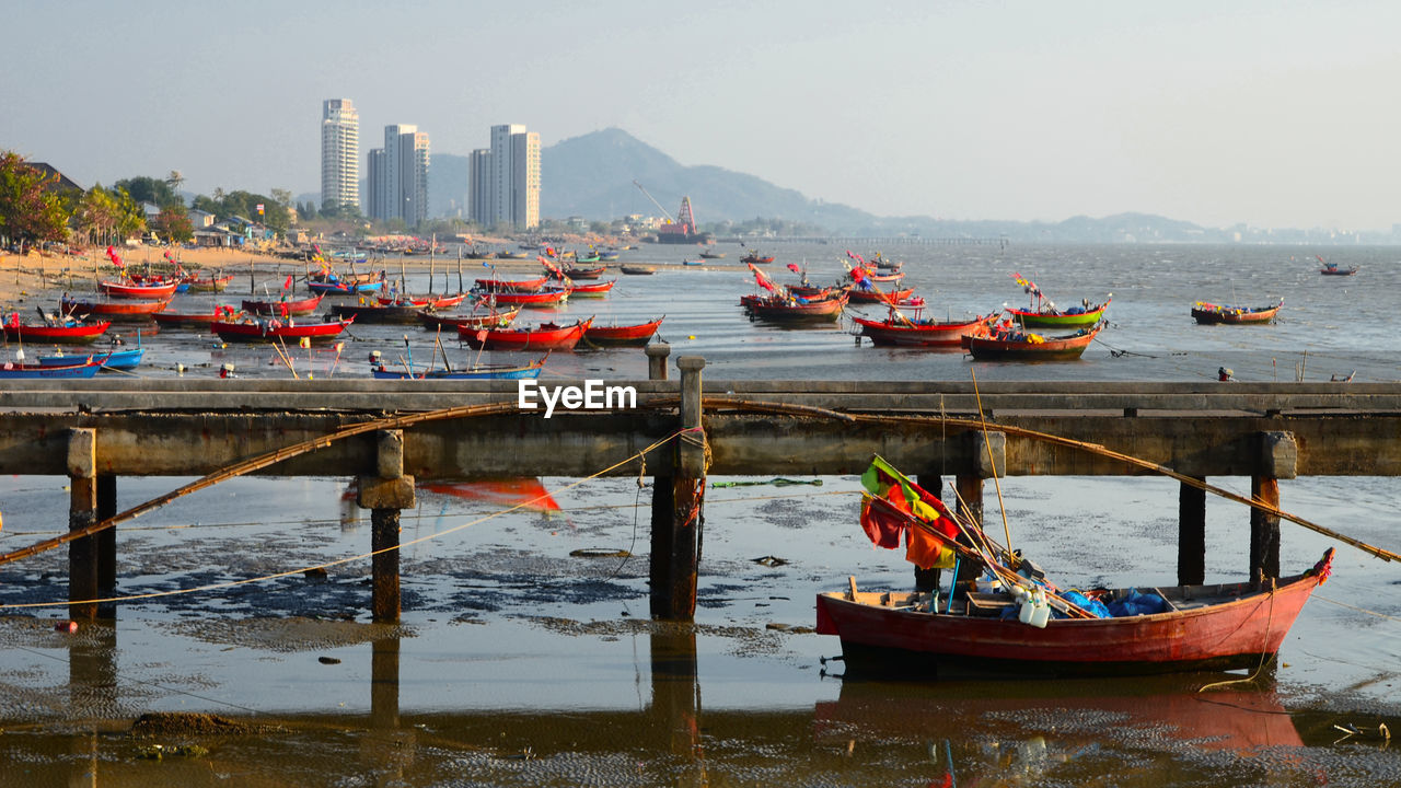 Boats moored in sea against sky