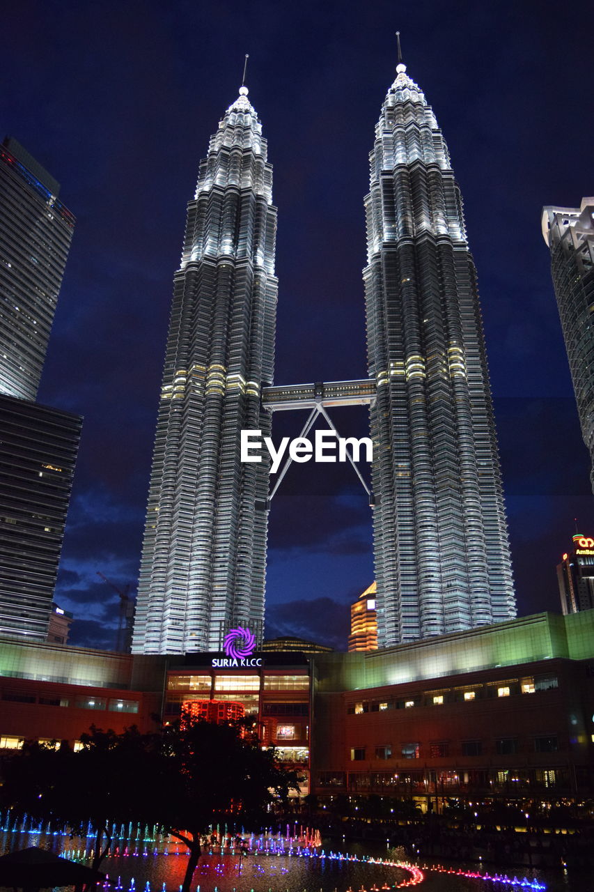 Low angle view of illuminated buildings against sky at night