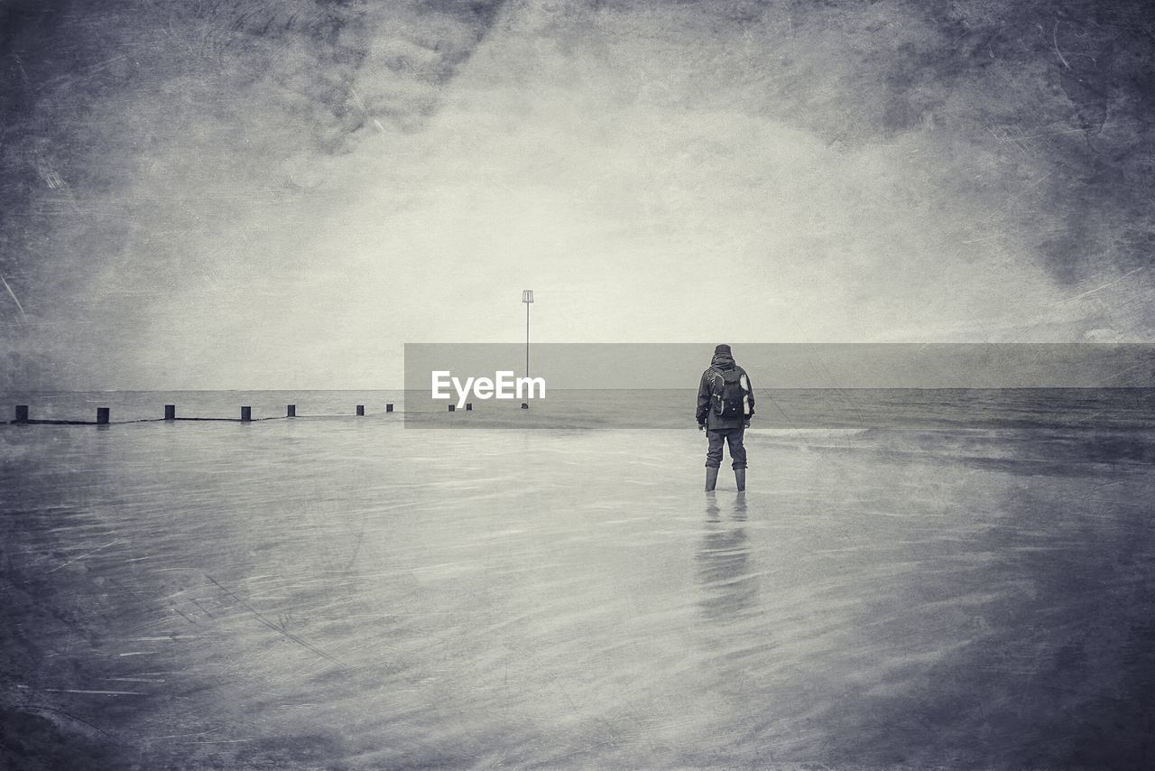 WOMAN STANDING ON BEACH