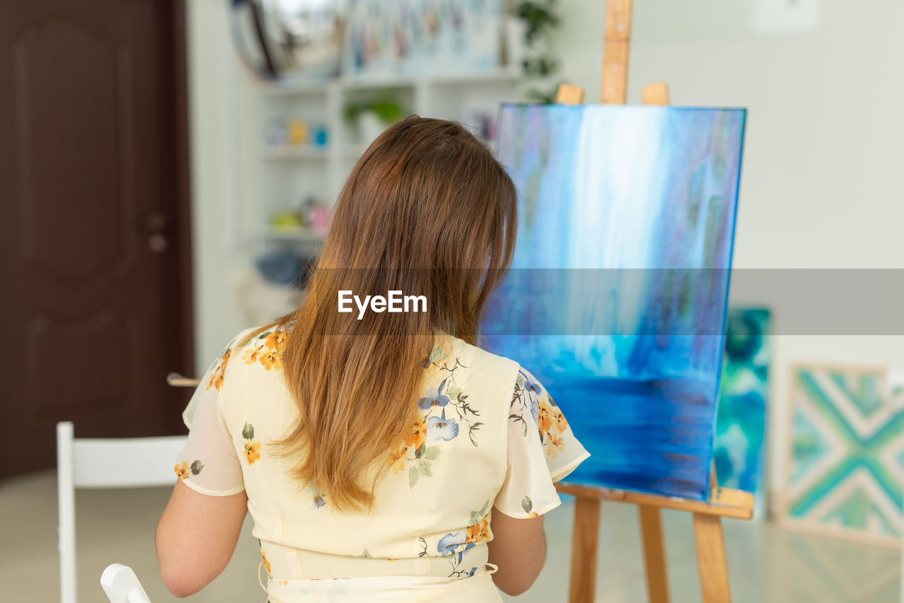 Rear view of woman wearing sunglasses at home