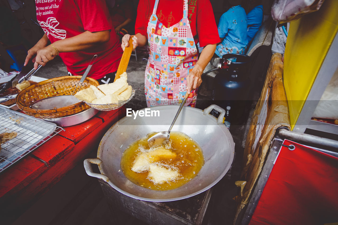 HIGH ANGLE VIEW OF PEOPLE PREPARING FOOD AT HOME