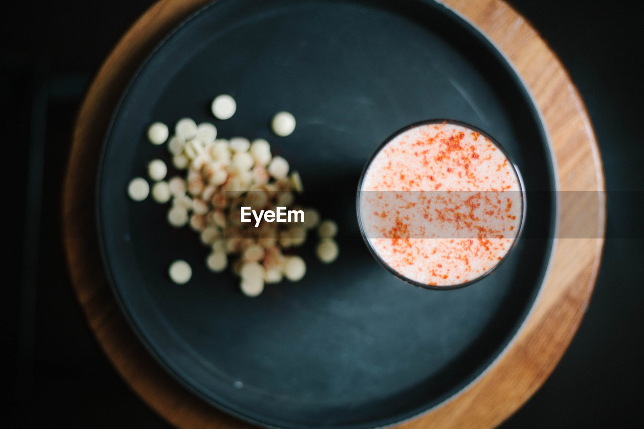 Directly above shot of chocolate chips and drink in plate on table