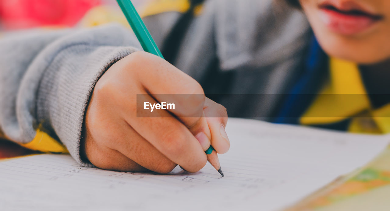 Close-up of boy writing on paper