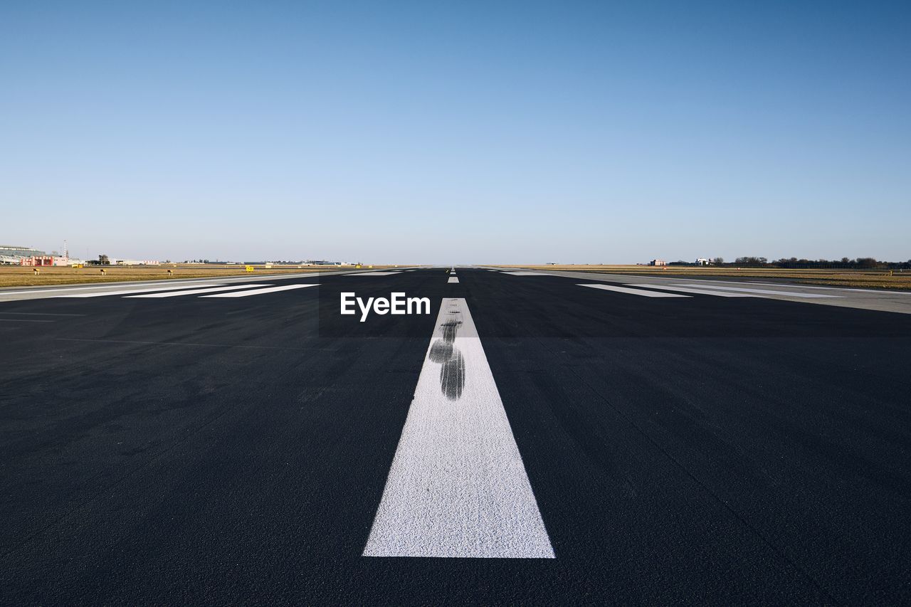 Airport runway against clear sky