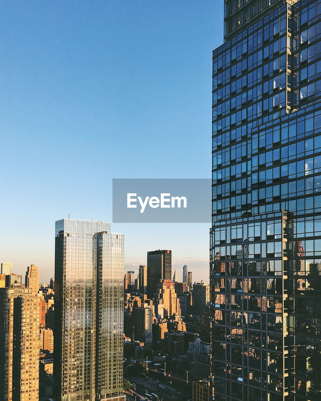 Modern buildings against clear blue sky in city