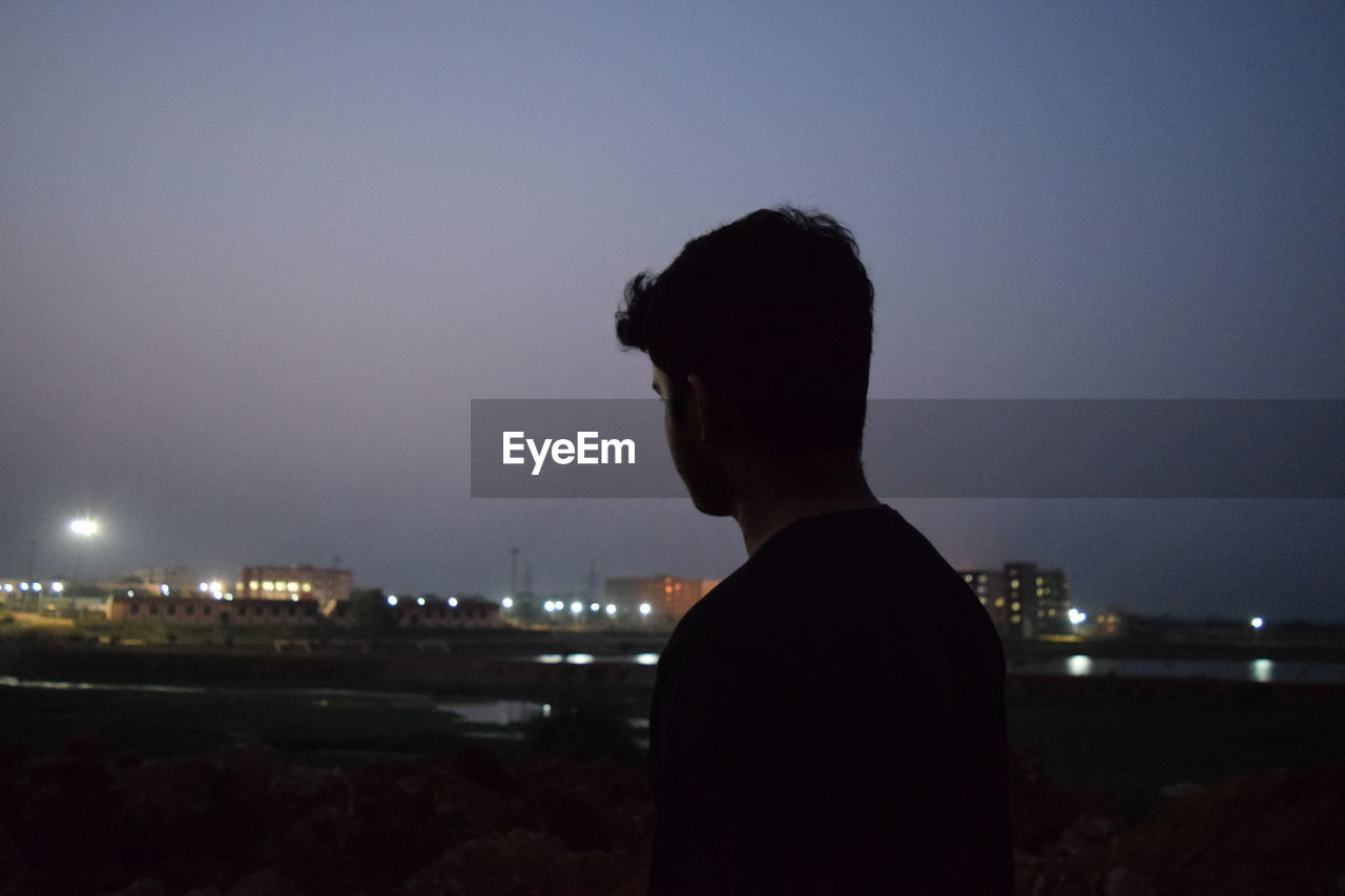 Man against clear sky at night