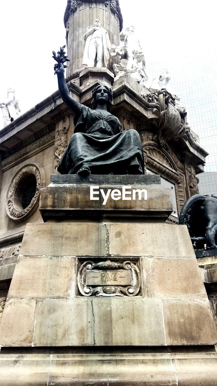 LOW ANGLE VIEW OF ANGEL STATUE AGAINST BUILDING