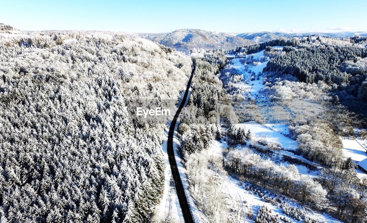 High angle view of road amidst trees during winter