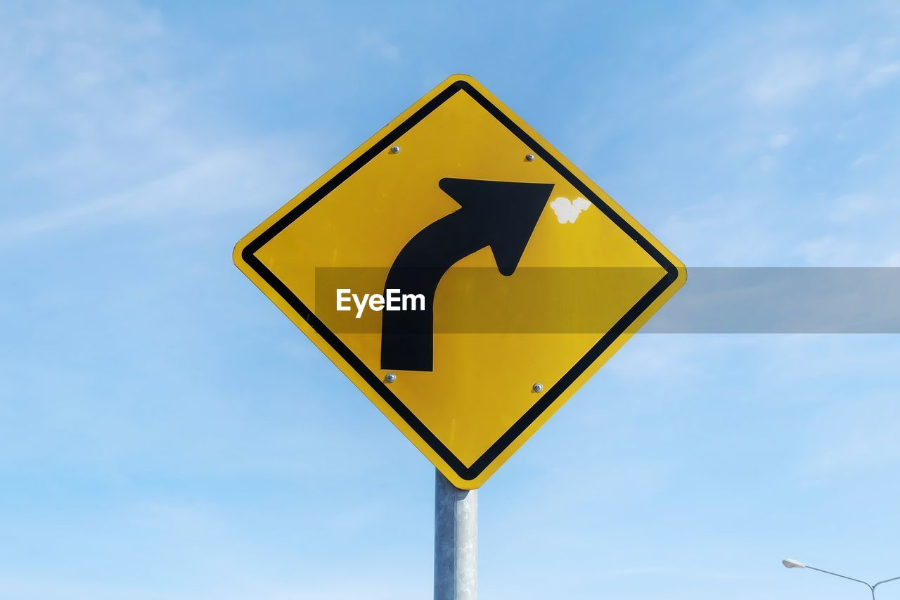 Low angle view of road sign against sky