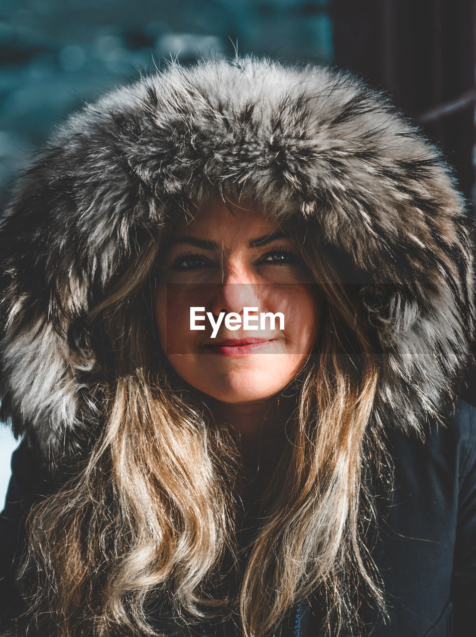 Close-up portrait of smiling young woman wearing warm clothing during winter