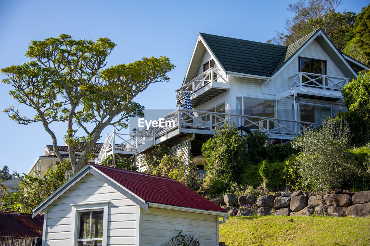 architecture, building exterior, built structure, building, house, residential district, home, residential area, estate, plant, tree, cottage, nature, front or back yard, farmhouse, home ownership, mansion, suburb, sky, rural area, blue, facade, neighbourhood, roof, no people, outdoors, village, window, clear sky, detached house, grass, day, wealth, city, lawn, luxury, sunlight, summer, landscaped, landscape
