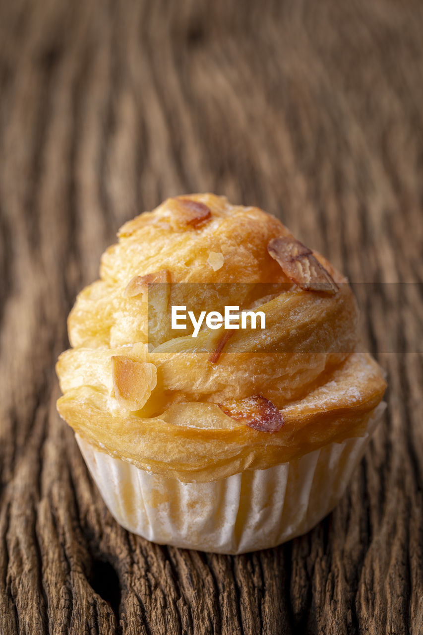 Almond cruffin with custard filling on rustic wood, cruffin is hybrid of croissant and muffin