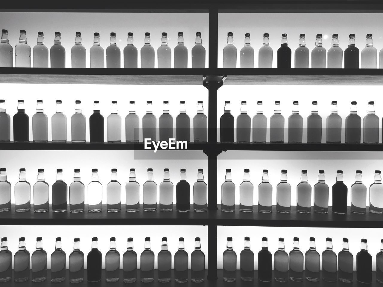 Full frame shot of alcohol bottles arranged on shelves