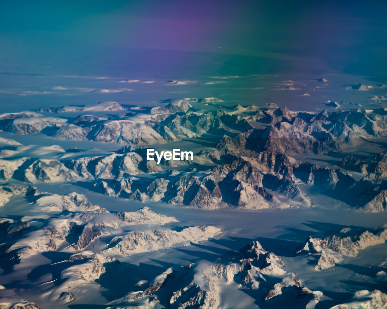 Aerial view of snowcapped mountains against sky