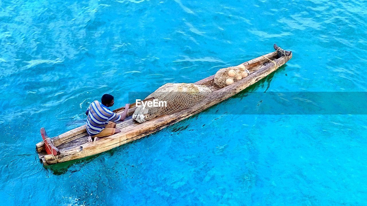 High angle view of man sitting in boat on sea