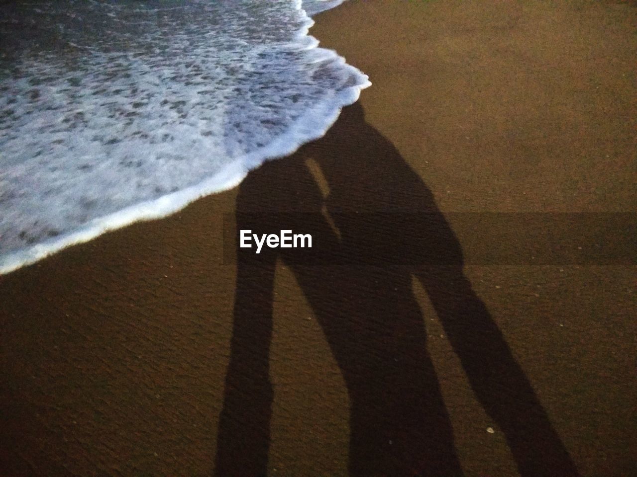 Shadow of couple standing at beach