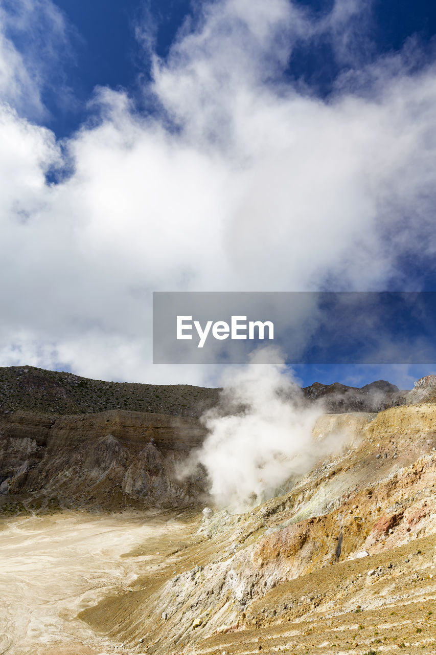 Scenic view of mountain range against cloudy sky