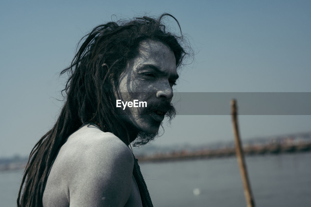 PORTRAIT OF MID ADULT MAN AGAINST SEA