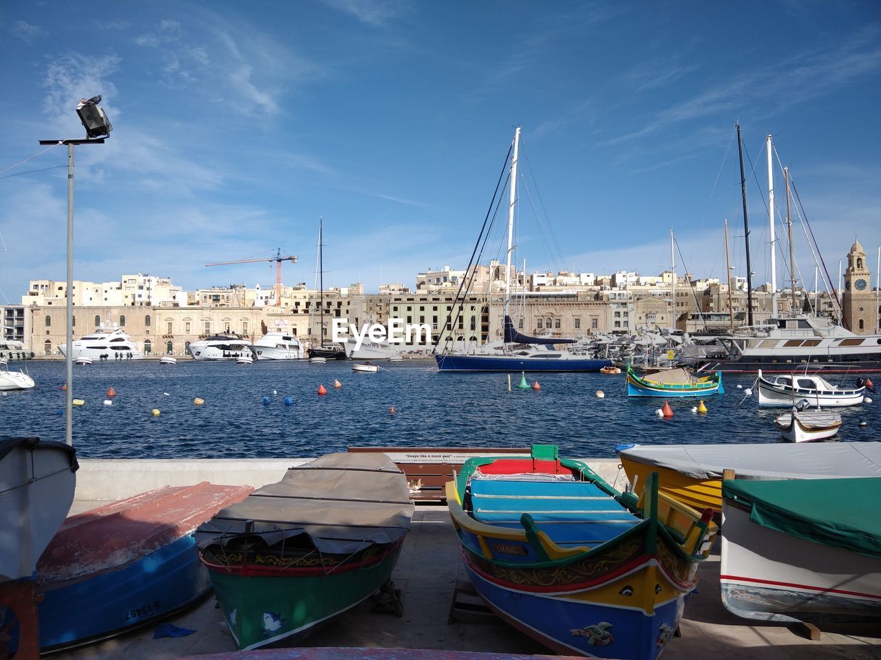 SAILBOATS MOORED AT HARBOR IN CITY