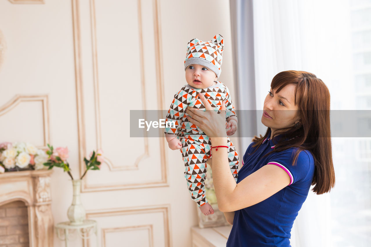 Side view of woman standing against wall