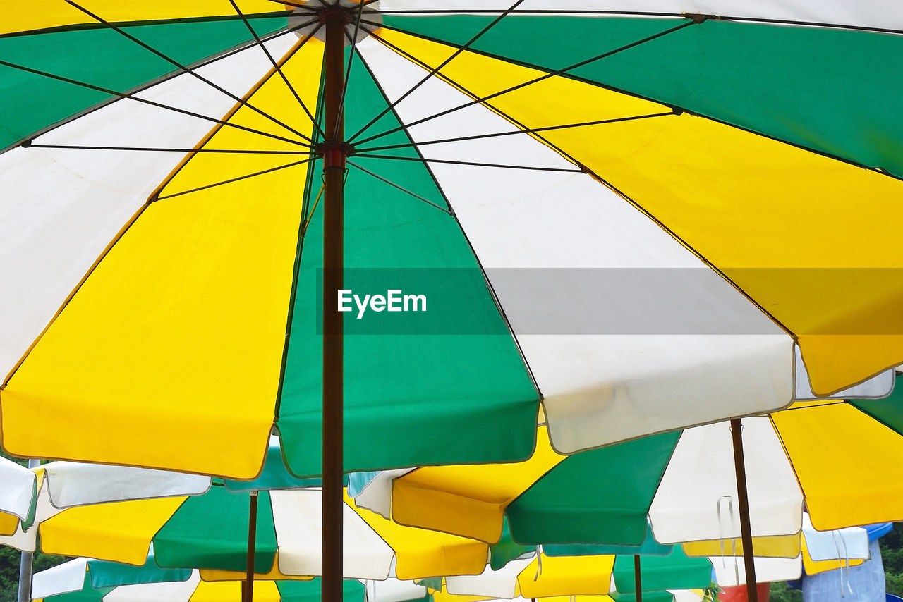 LOW ANGLE VIEW OF MULTI COLORED UMBRELLAS