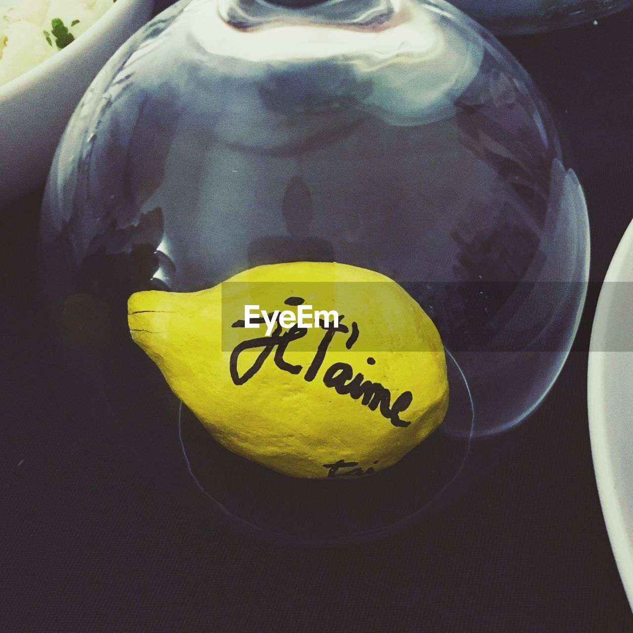 HIGH ANGLE VIEW OF YELLOW BOTTLE WITH WATER ON TABLE