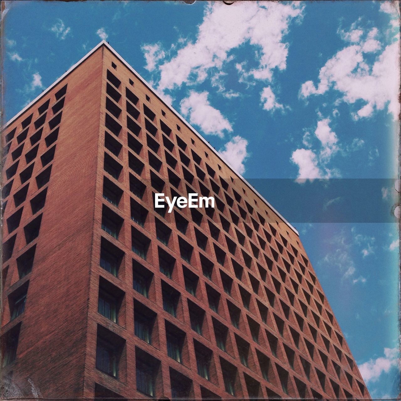 Low angle view of building against blue sky and clouds