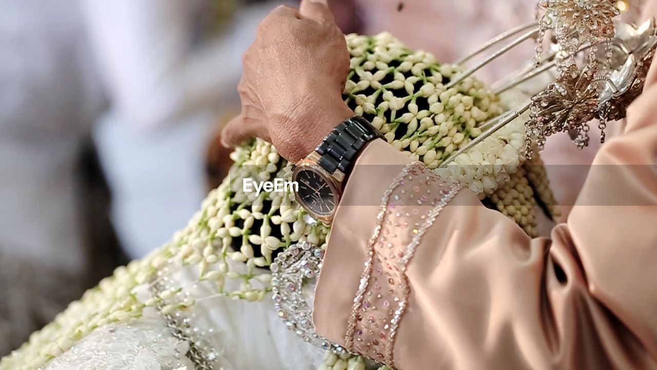 Midsection of woman giving blessing to bride in wedding ceremony