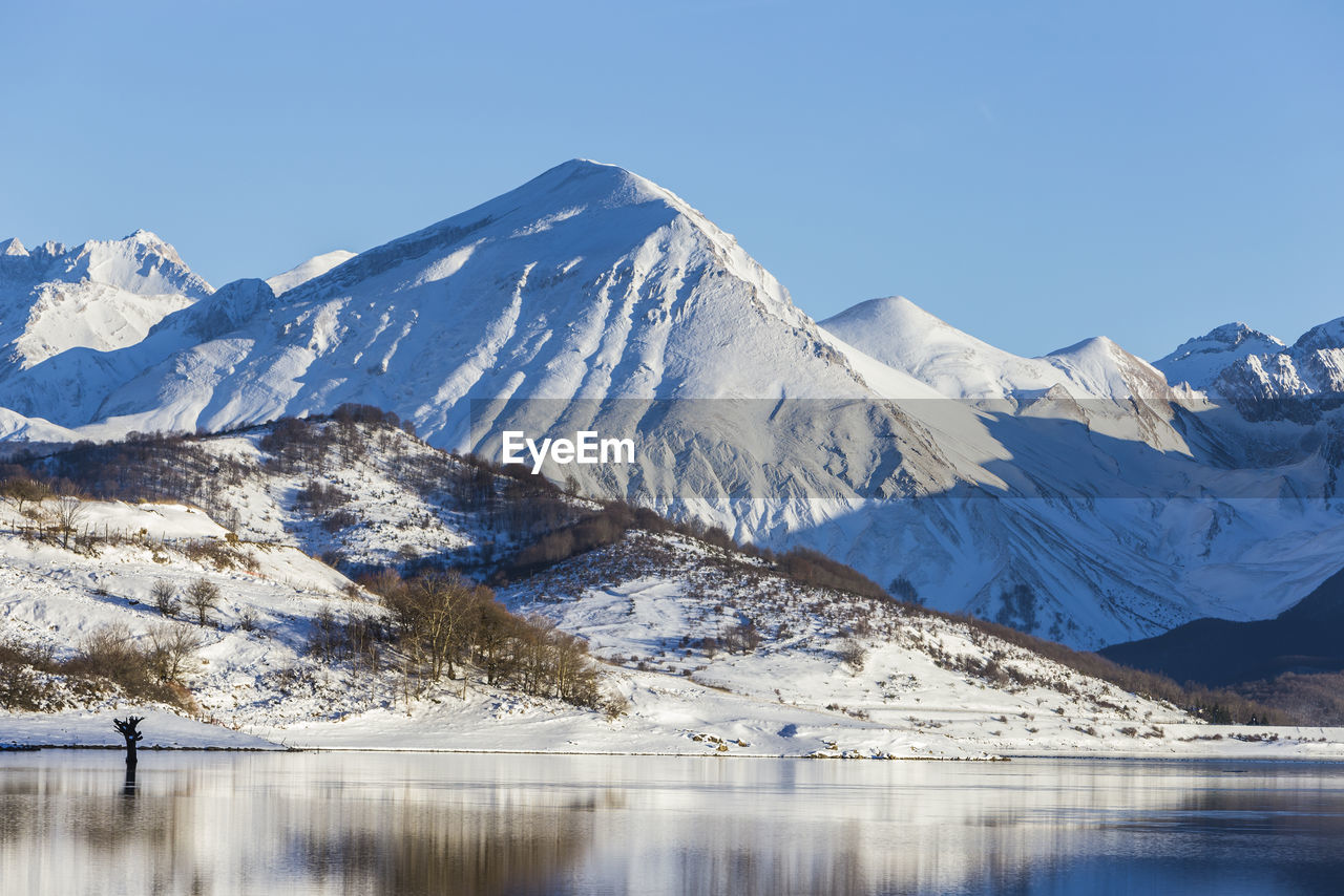 SCENIC VIEW OF LAKE AND SNOWCAPPED MOUNTAINS AGAINST SKY