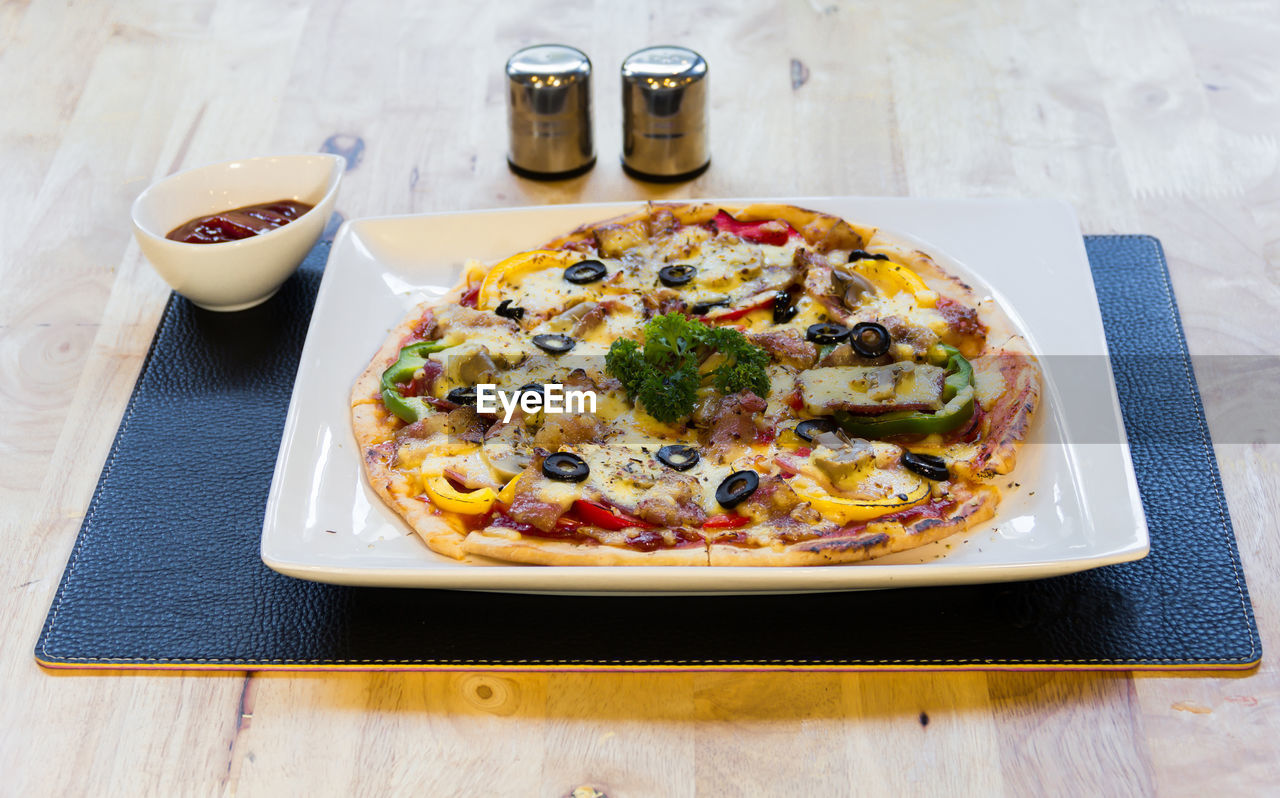 HIGH ANGLE VIEW OF PIZZA SERVED IN PLATE