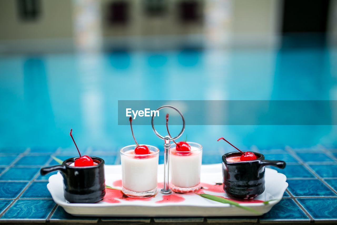 Dessert in tray against swimming pool