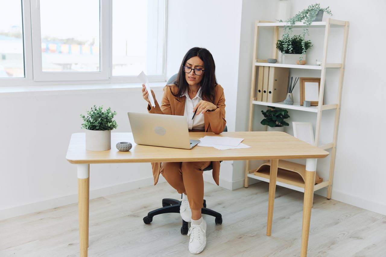 young woman using laptop while sitting on table at home