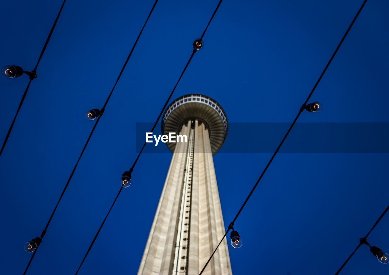 Low angle view of communications tower against blue sky