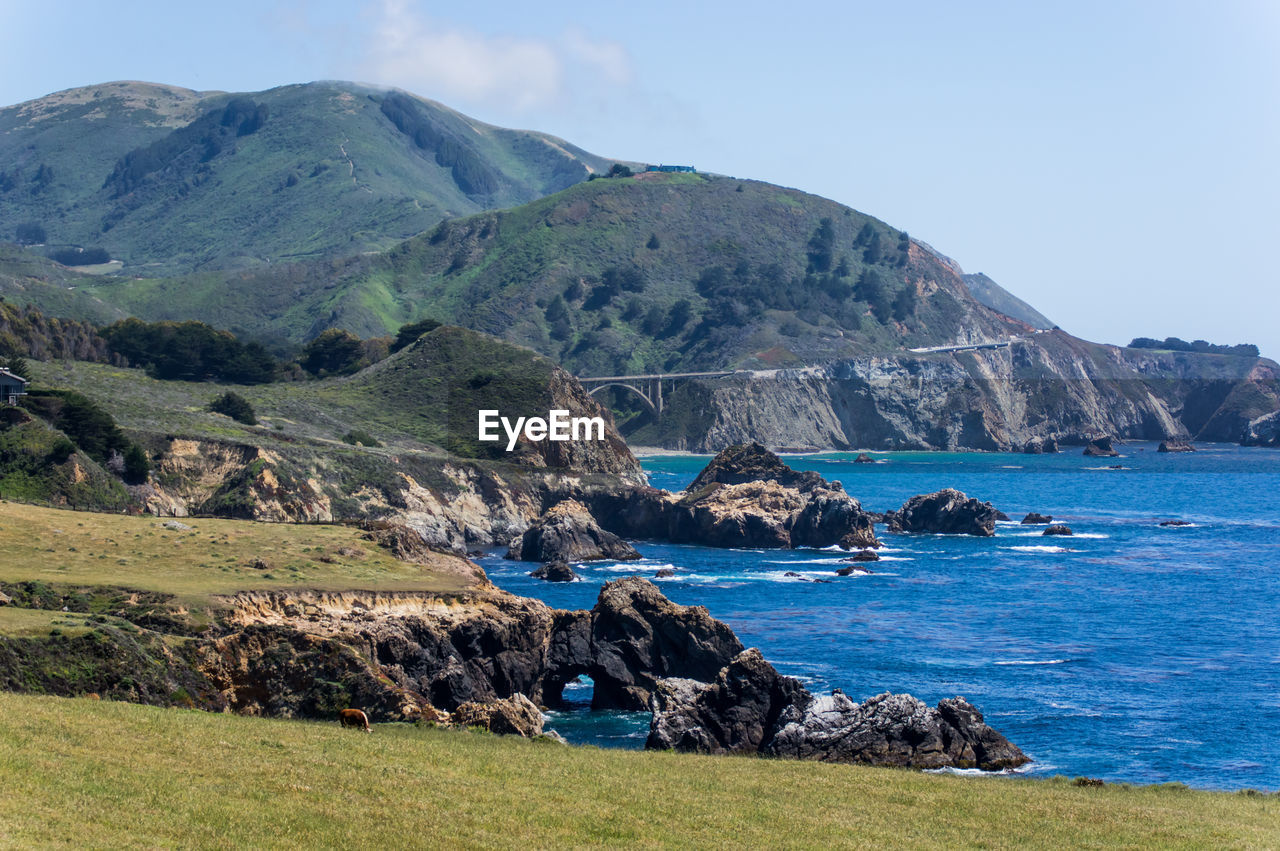 Scenic view of sea and mountains against sky