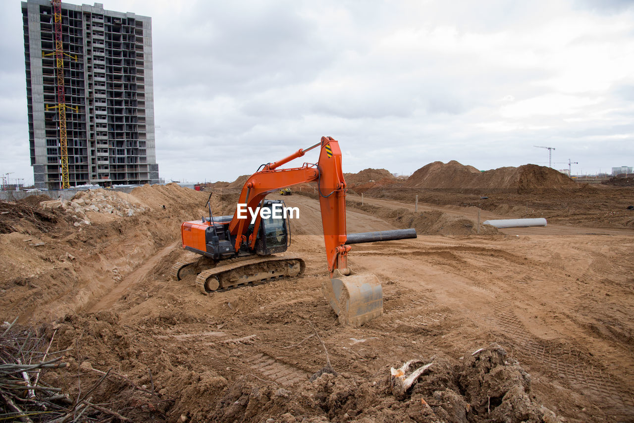 Red excavator during earthworks at construction site. backhoe digging the ground for the foundation