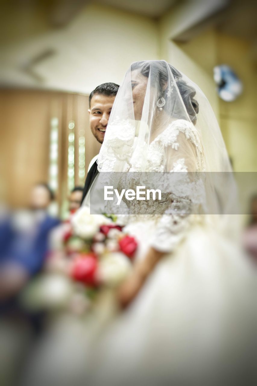 CLOSE-UP OF COUPLE HOLDING BOUQUET OF WEDDING