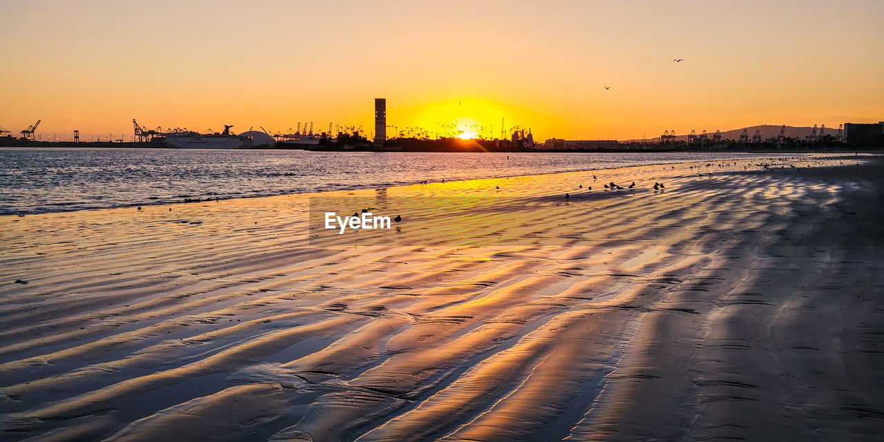 Scenic view of beach against sky during sunset