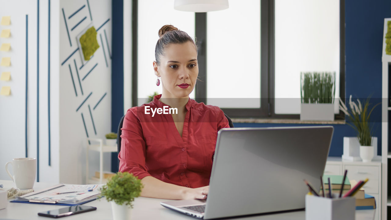 Businesswoman using laptop at desk