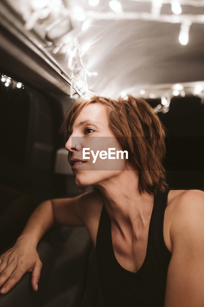 Mature woman looking through window while travelling in van