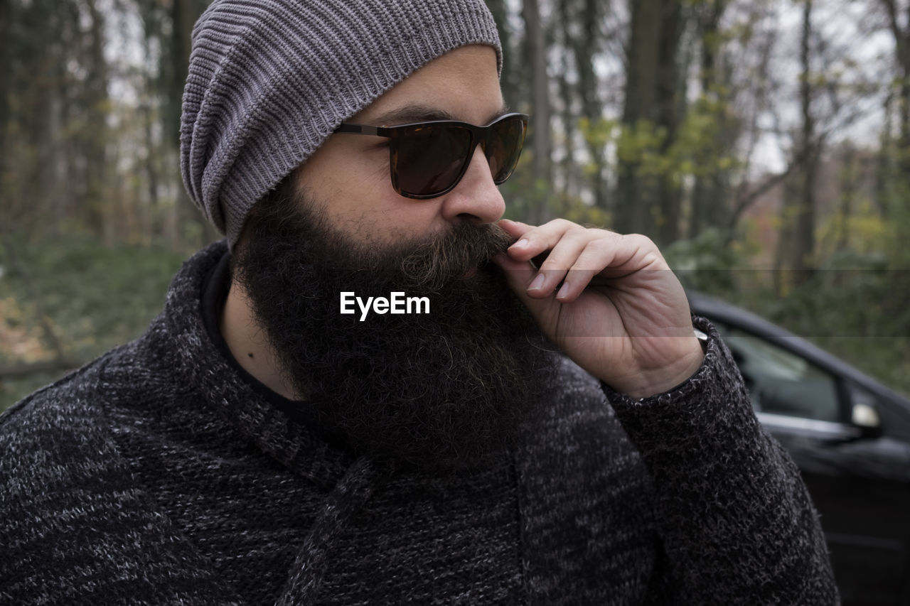 Close-up of man wearing sunglasses standing in forest