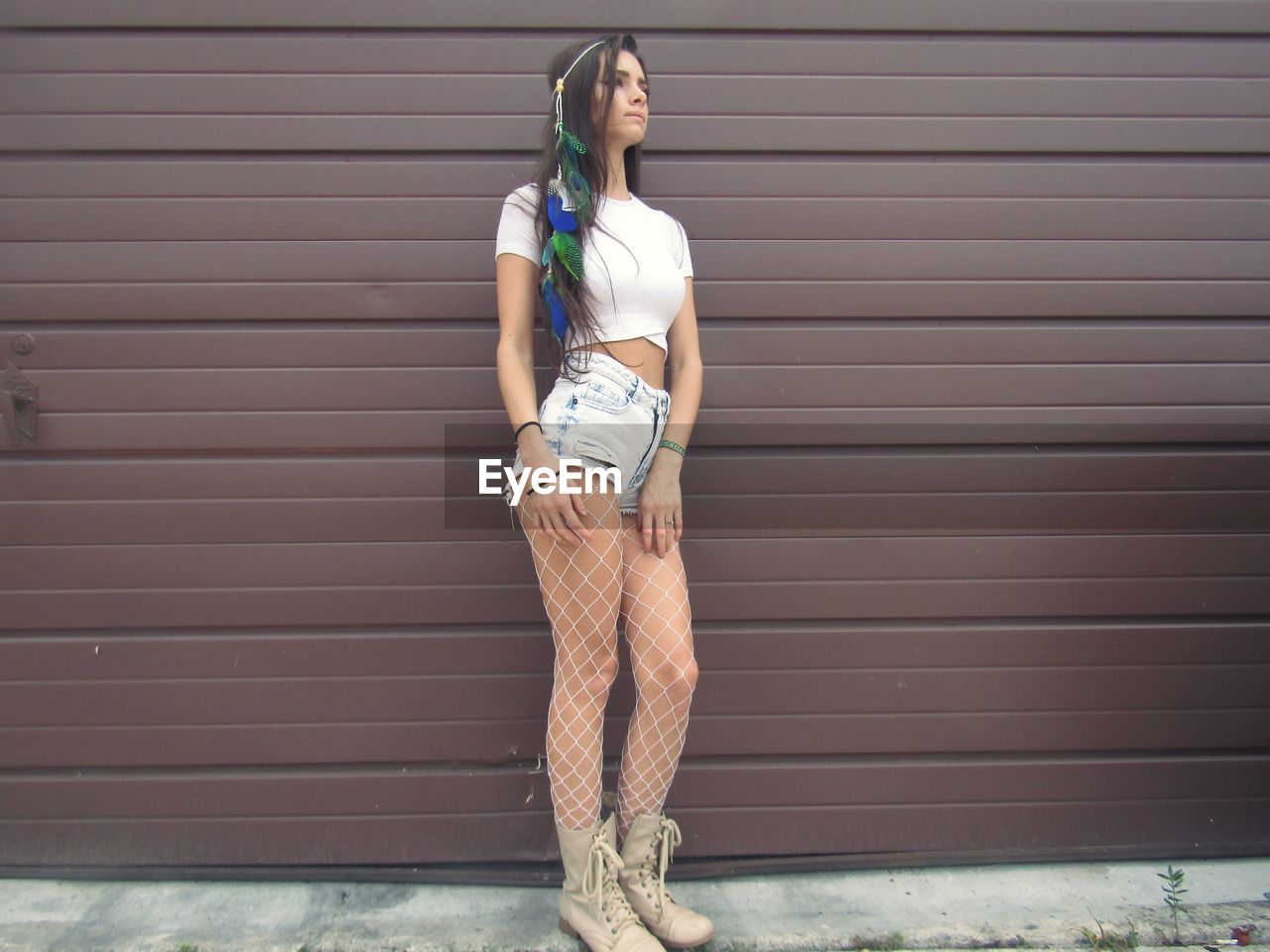 YOUNG WOMAN STANDING ON SHUTTER