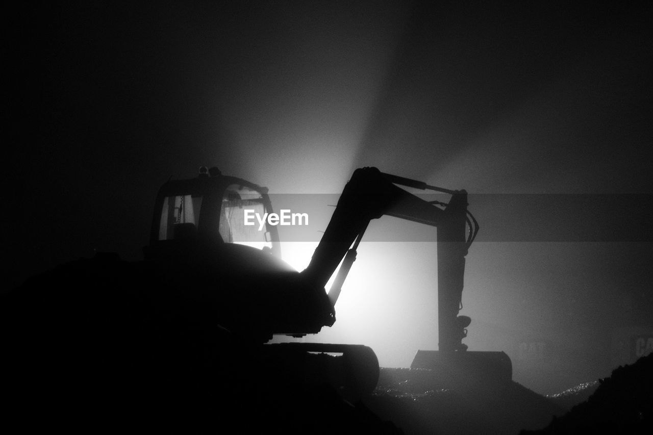 Low angle view of bulldozer on field at night