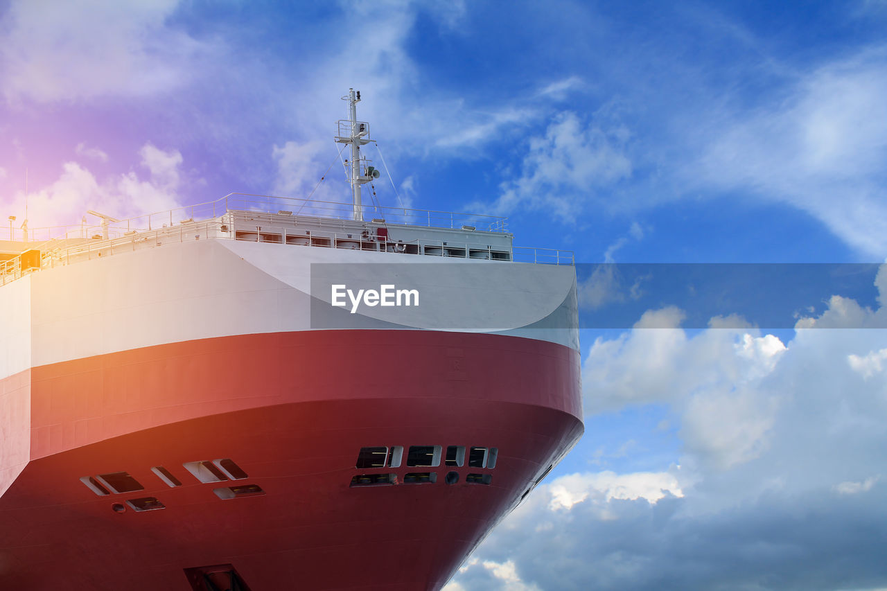 LOW ANGLE VIEW OF RED SHIP AGAINST BLUE SKY